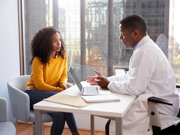 Doctor advising young lady in his office - CIC Health Insurance