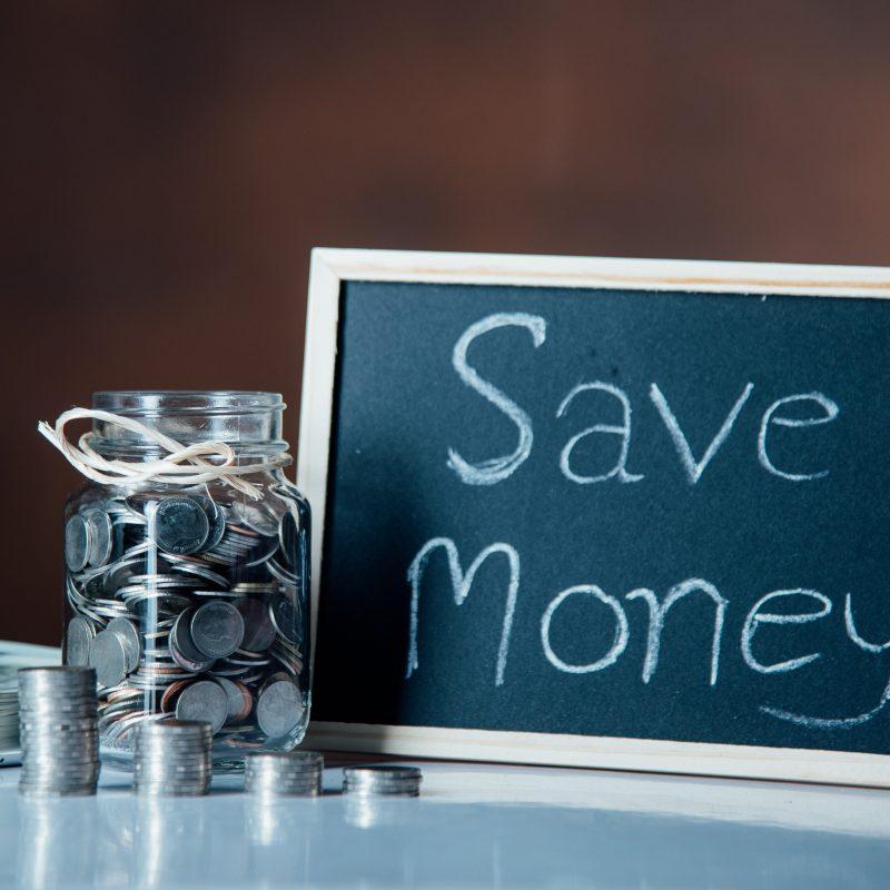 Save money writing on a small board next to a jar full of coins